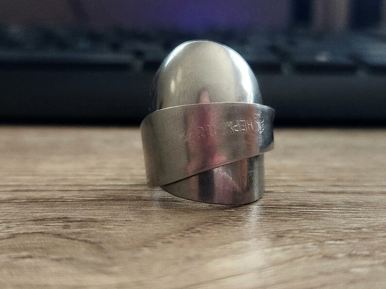 K&ouml;nnte beinhalten: Ein silberner Ring aus einem verdrehten L&ouml;ffel. Der L&ouml;ffel tr&auml;gt die Gravur "HEPBURN".