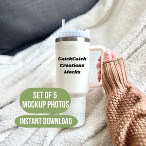 May include: White stainless steel tumbler with a black handle and a straw. The tumbler has the text "CatchCatch Creations Mocks" printed on it. The tumbler is sitting on a white blanket and a hand is holding it. The text "Set of 5 Mockup Photos" and "Instant Download" are printed below the tumbler.