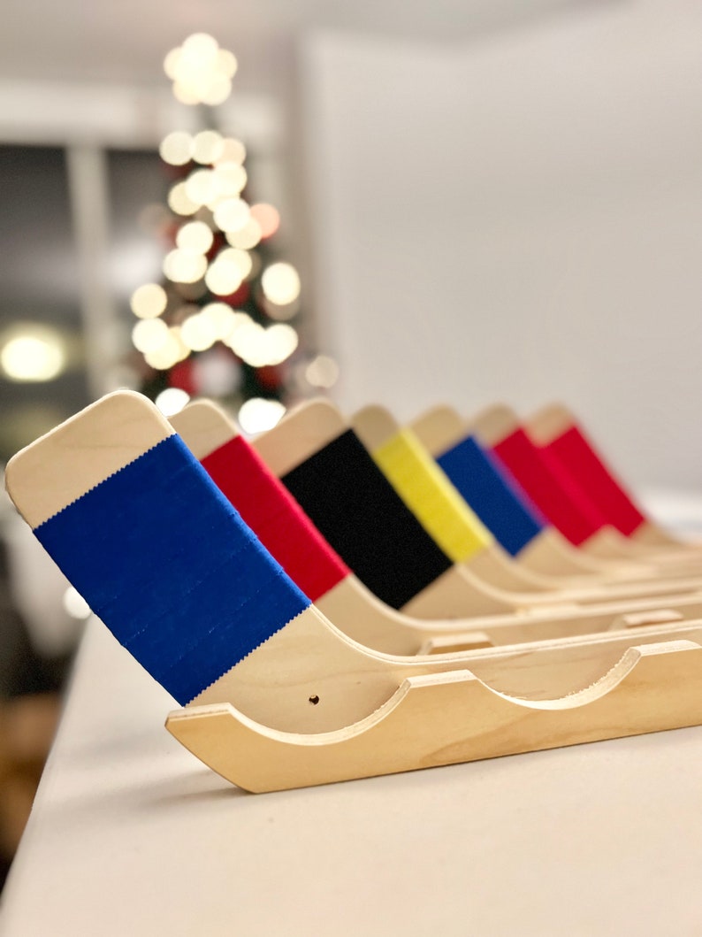 Puede incluir: Un conjunto de seis soportes de palo de hockey de madera con detalles de cinta de colores. Los soportes est&aacute;n dispuestos en fila, con el soporte de cinta azul en primer plano. Los soportes est&aacute;n hechos de madera natural y tienen un dise&ntilde;o simple y elegante.