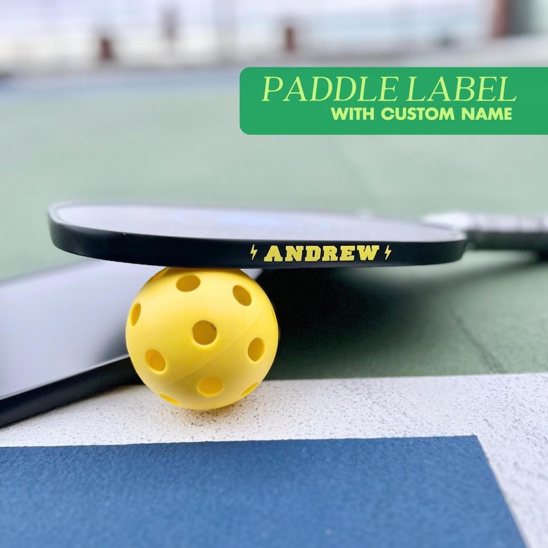 Pickleball paddle name label with custom graphic to be applied to the edge guard of a pickleball paddle so that it's fully personalized