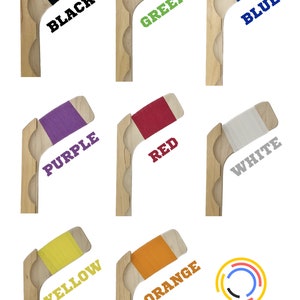 Puede incluir: Nueve palos de hockey de madera con tiras de fieltro de diferentes colores en la hoja. Los colores son negro, verde, azul, morado, rojo, blanco, amarillo, naranja y un logotipo con el texto "catchcatch creations".