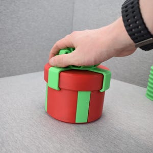 Könnte beinhalten: Ein Set aus drei Keramikbechern mit gesprenkelter, matter Oberfläche. Die Becher sind in Creme-, Hellgrau- und Dunkelgrautönen gehalten. Jede Tasse hat ein schlichtes, minimalistisches Design, ideal für Kaffee oder Tee.