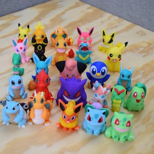 May include: A collection of 20 colourful Pokemon figurines, including Pikachu, Charmander, Bulbasaur, Squirtle, and many more. The figurines are made of plastic and are approximately 5 cm tall.