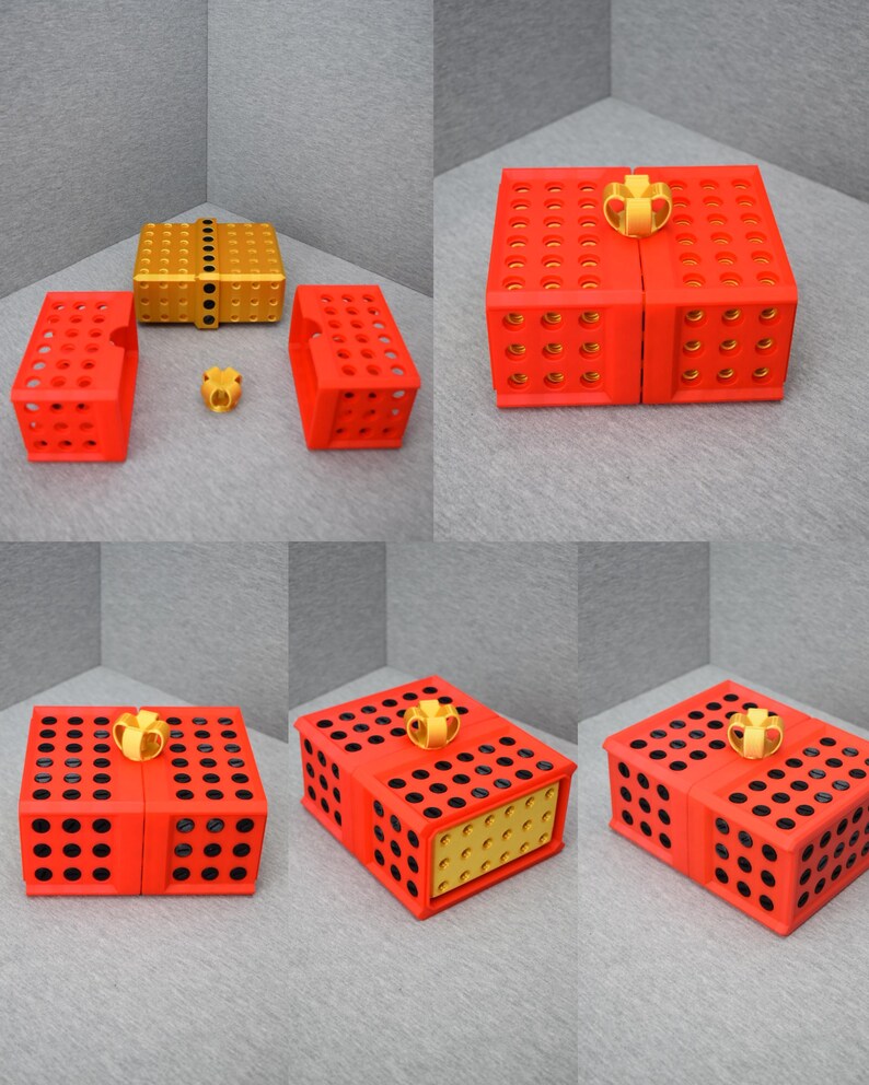 Op de afbeelding: Een rode en zwarte cadeaudoos met een gouden strik. De doos is gemaakt van plastic en heeft een rasterpatroon aan de zijkanten. De doos is open en de binnenkant is zichtbaar. De binnenkant van de doos is goud.
