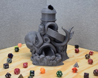 May include: A 3D printed gray octopus-themed dice tower with a slide and a hole in the top. The tower is surrounded by colorful dice on a wooden surface.