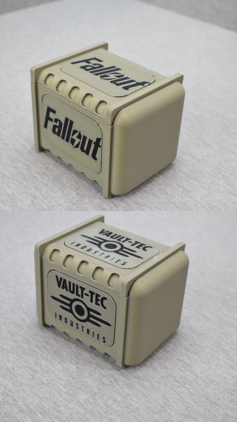 以下が含まれることがあります： 前面に黒い「Fallout」ロゴ、側面に黒い「Vault-Tec Industries」ロゴが付いたベージュの箱