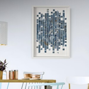 May include: A framed abstract art print with a blue and white colour scheme. The print features a geometric pattern of rectangular shapes.