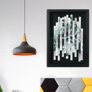 May include: Abstract art print with a black frame. The print features a design of vertical strips of white and blue watercolour on a black background.