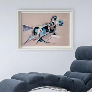 May include: Abstract art print in a white frame with a blue and white geometric design on a light pink background.