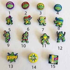 May include: Set of 15 Teenage Mutant Ninja Turtles themed shoe charms. The charms feature different characters from the franchise, including Leonardo, Donatello, Raphael, Michelangelo, and Master Splinter. The charms are made of plastic and are approximately 1 inch in size.