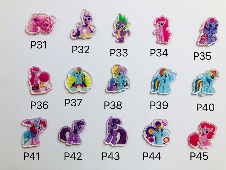 May include: A set of 15 colorful My Little Pony character charms. The charms are made of clear plastic with a printed image of a pony on each one. The charms are numbered P31 through P45.
