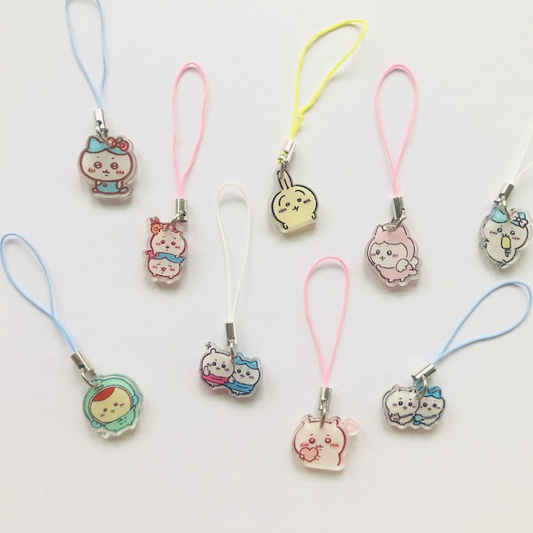 May include: Nine colorful phone charms with different cartoon animal designs. The charms are attached to strings of various colors, including pink, blue, yellow, and white.