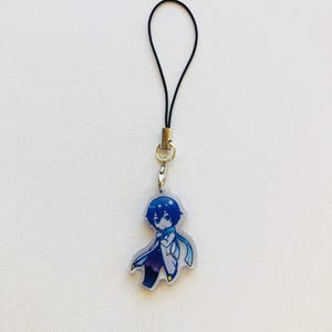 Peut inclure: Un porte-cl&eacute;s de style anime bleu et blanc repr&eacute;sentant un personnage aux cheveux bleus et une &eacute;charpe. Le porte-cl&eacute;s est attach&eacute; &agrave; un cordon noir avec un fermoir dor&eacute;. Le personnage porte un manteau blanc et un pantalon violet.