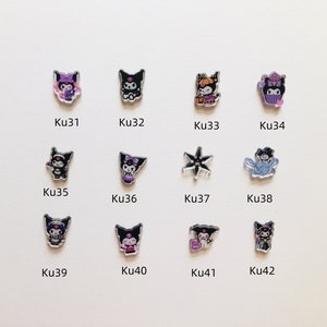 Op de afbeelding: Een verzameling van twaalf acryl bedels met verschillende stripfiguren in verschillende poses en outfits. De bedels zijn in verschillende kleuren, waaronder zwart, paars en oranje, en zijn gelabeld met de codes Ku31 tot Ku42.