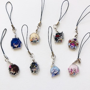 Könnte beinhalten: Eine Sammlung von acht Acryl-Anhängern mit farbenfrohen Illustrationen im Anime-Stil. Jeder Anhänger ist an einer schwarzen Kordelschlaufe mit einem silbernen Metallverschluss befestigt und zeigt verschiedene Figuren mit individuellen Outfits.