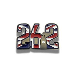 Puede incluir: Pin metálico con el número "26.2" con un diseño de la Union Jack. El pin incluye una silueta del Big Ben. El pin tiene un borde dorado y está sobre un fondo blanco.