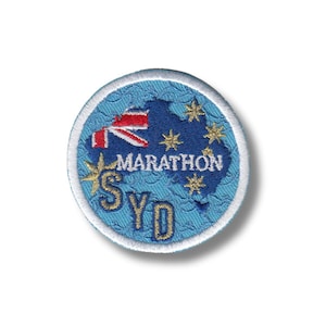 Puede incluir: Un parche bordado azul y blanco con un mapa de Australia, la bandera australiana y el texto "MARATHON SYDNEY".