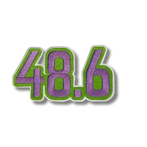 Op de afbeelding: Geborduurde patch met het nummer "48.6". De cijfers zijn paars met een glittertextuur, omlijnd in groen. De patch heeft een witte rand en is ontworpen om op stof te strijken of te naaien.