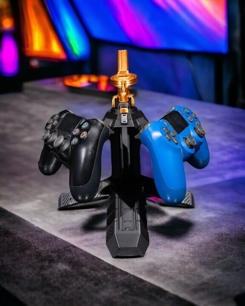 May include: A black and gold controller stand with three slots for controllers. Two controllers are on the stand, one black and one blue.