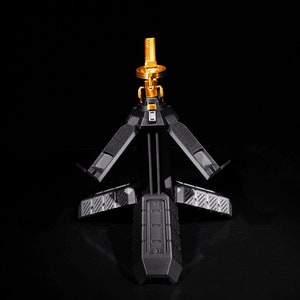 May include: A black tripod stand with a gold metal top. The tripod has three legs that fold out and a textured surface.