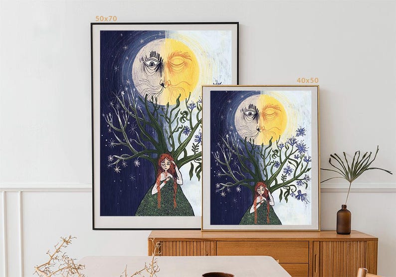 Puede incluir: Dos l&aacute;minas de arte mural enmarcadas que muestran un rostro dividido en sol y luna sobre una persona de pelo largo y rojo. La persona est&aacute; bajo un &aacute;rbol con un lado que muestra estrellas y el otro flores azules. Se indican los tama&ntilde;os 50x70 y 40x50.