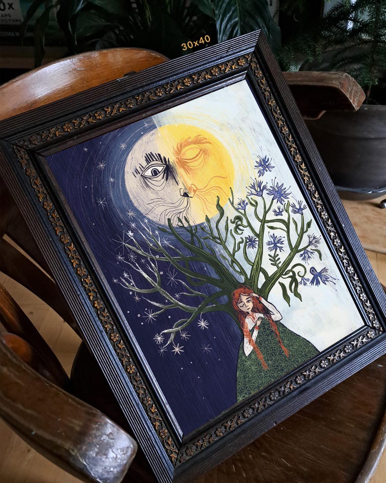 Puede incluir: Un cuadro enmarcado de 30x40 cm que muestra un rostro dividido en sol y luna sobre una persona de largo cabello rojo. La persona est&aacute; frente a un &aacute;rbol con flores azules, sobre un fondo de cielo estrellado azul oscuro y un fondo amarillo claro.