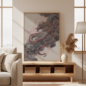 Puede incluir: Ilustración enmarcada de un dragón gris con detalles rojos, sobre un fondo de nubes grises oscuras y líneas rojas. La obra de arte se exhibe en un salón. El dragón es el punto focal, con un fondo beige claro.