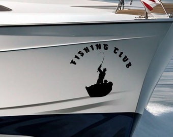 Könnte beinhalten: Ein weißes Motorboot mit blauem Rumpf ist auf einem Gewässer unterwegs. Das Boot hat eine große Windschutzscheibe und eine kleine amerikanische Flagge. Die Worte "FISHING CLUB" und eine Silhouette eines Fischers befinden sich am Bug.