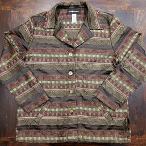 Puede incluir: Una chaqueta abotonada de color marrón, verde y rojo con cuello. La chaqueta tiene un patrón geométrico y está hecha de una tela sedosa. La marca "Sea Harbor" es visible en la etiqueta.