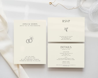 Op de afbeelding: Een huwelijksuitnodigingsset met een crèmekleurige achtergrond en zwarte tekst. De uitnodigingskaart heeft een eenvoudige illustratie van twee ringen met een diamant. De RSVP-kaart heeft een bloemillustratie en de detailkaart bevat de datum, locatie en dresscode.