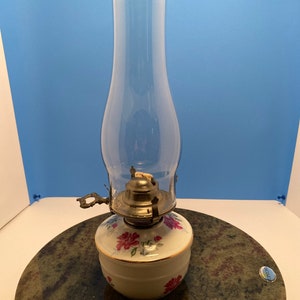 Oil lamp with roses.  Globe included. 13 3/4” tall.