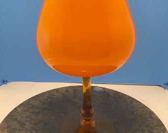 midcentury orange art glass vase on a gold stem.