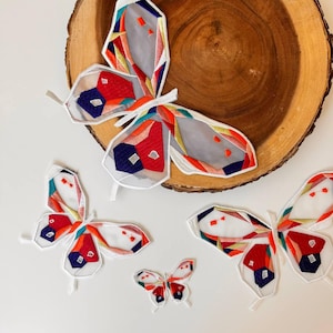 May include: Four embroidered butterfly patches in various colors and patterns. The butterflies are made of fabric and have a geometric design. The patches are perfect for adding a touch of whimsy to clothing, bags, or other accessories.