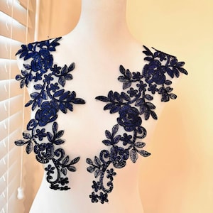 以下が含まれることがあります： 花柄のネイビーブルーのレースアップリケ2枚。アップリケは繊細なレースでできており、複雑な花柄が特徴です。どんなプロジェクトにもエレガントなタッチを加えるのに最適です。