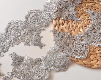 Puede incluir: Ribete de encaje plateado con detalles florales y de cuentas. El delicado ribete presenta un borde festoneado y es ideal para embellecer prendas, accesorios o proyectos de decoración del hogar. El diseño intrincado añade un toque de elegancia.