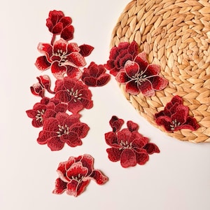 May include: A set of ten red velvet flower appliques with gold embroidery. The appliques are perfect for adding a touch of elegance to any project.