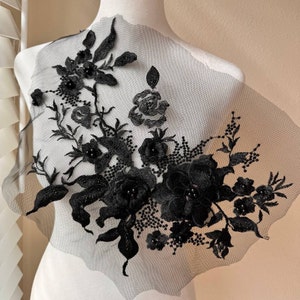 May include: Black lace applique with beaded embellishments. The applique features floral designs and is perfect for adding a touch of elegance to any project.