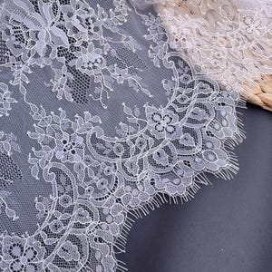 May include: White lace trim with a delicate floral pattern. The lace has a scalloped edge and is perfect for adding a touch of elegance to any project.