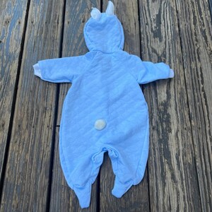 Puede incluir: Un disfraz de conejito para beb&eacute; en azul claro con un dise&ntilde;o acolchado. El mono con capucha presenta orejas de conejo blancas, pu&ntilde;os blancos y una cola blanca y esponjosa. Para beb&eacute;s y ni&ntilde;os peque&ntilde;os.