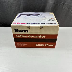 May include: A Bunn coffee decanter in its original box. The box is white and brown with the Bunn logo and the words "coffee decanter" and "Easy Pour" printed on it. The box also features an image of the decanter.
