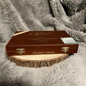 May include: A wooden box with a gold label that reads "Oliva Serie V Melanio Gran Reserva Limitada" and "Oliva Serie V Melanio".