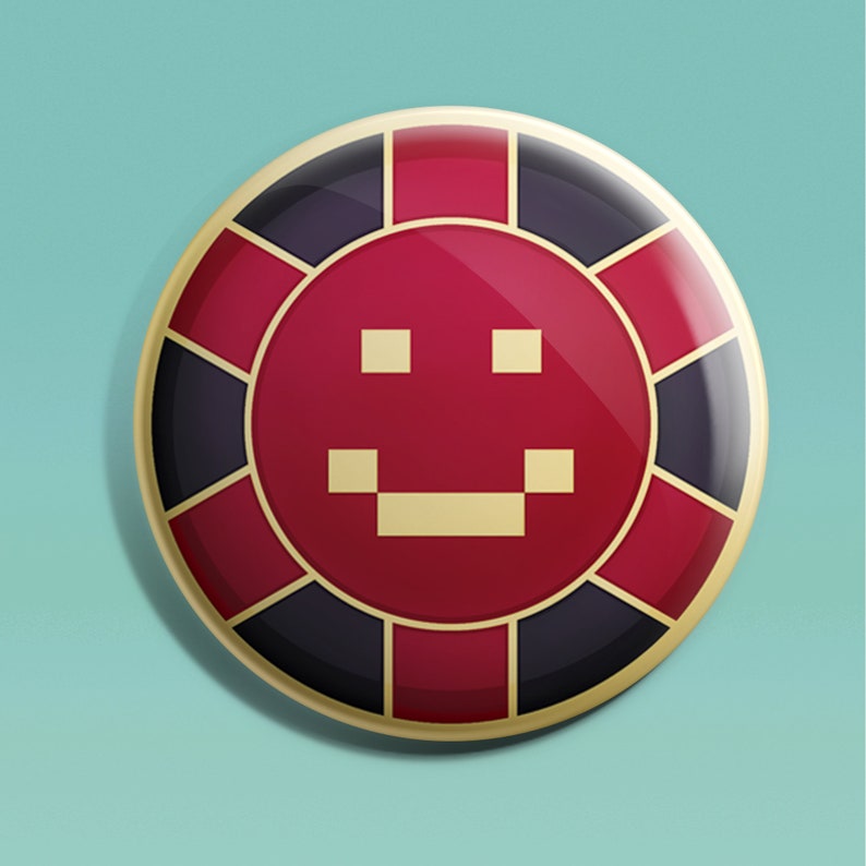 May include: A red and black casino chip with a gold border and a pixelated smiley face in the center.