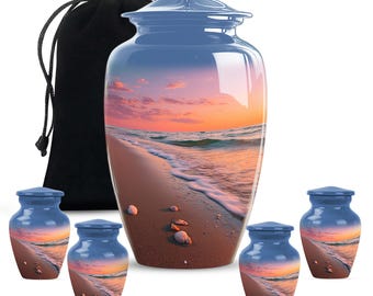 May include: A collection of blue cremation urns with a beach scene design. The set includes a large urn, a black velvet bag, and four smaller keepsake urns. The beach scene features a sunset over the ocean with seashells on the sand.