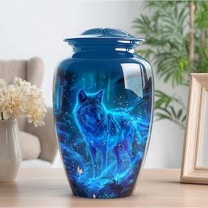 May include: A blue cremation urn with a glossy finish. The urn features a vibrant illustration of a glowing blue wolf in a forest setting. The design includes details of trees and ethereal light effects, creating a mystical scene.