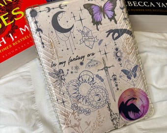 May include: A clear phone case with a whimsical design featuring a purple butterfly, a crescent moon, a sun, a sword, and the text "In my fantasy era".