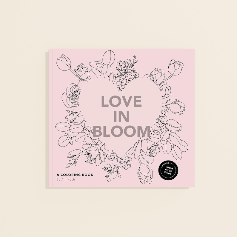 May include: A pink coloring book titled "Love in Bloom" with a heart-shaped floral design. The book cover features the text "A Coloring Book By Alli Koch" and a small circle that says "Bonus Velvet Pages Inside."