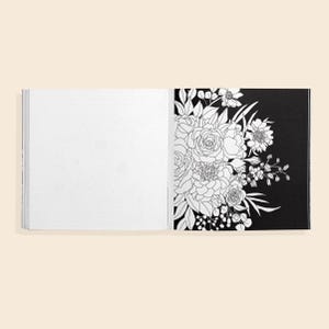 May include: An open coloring book with a black page featuring a line drawing of a bouquet of flowers. The opposite page is blank, ready for coloring.