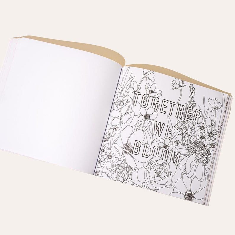 May include: Open coloring book with the text "TOGETHER WE BLOOM" surrounded by floral line art. The book is open to a blank page and a page with detailed flower illustrations. The cover is a light tan color.