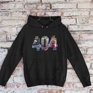 Può includere: Felpa con cappuccio nera con una stampa grafica del numero 404 composta da immagini.