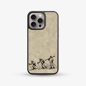 May include: Phone case featuring a black and white illustration of three skiers in action. The skiers are depicted in a vintage style, with one carrying skis over their shoulder. The case has a textured, tan background.